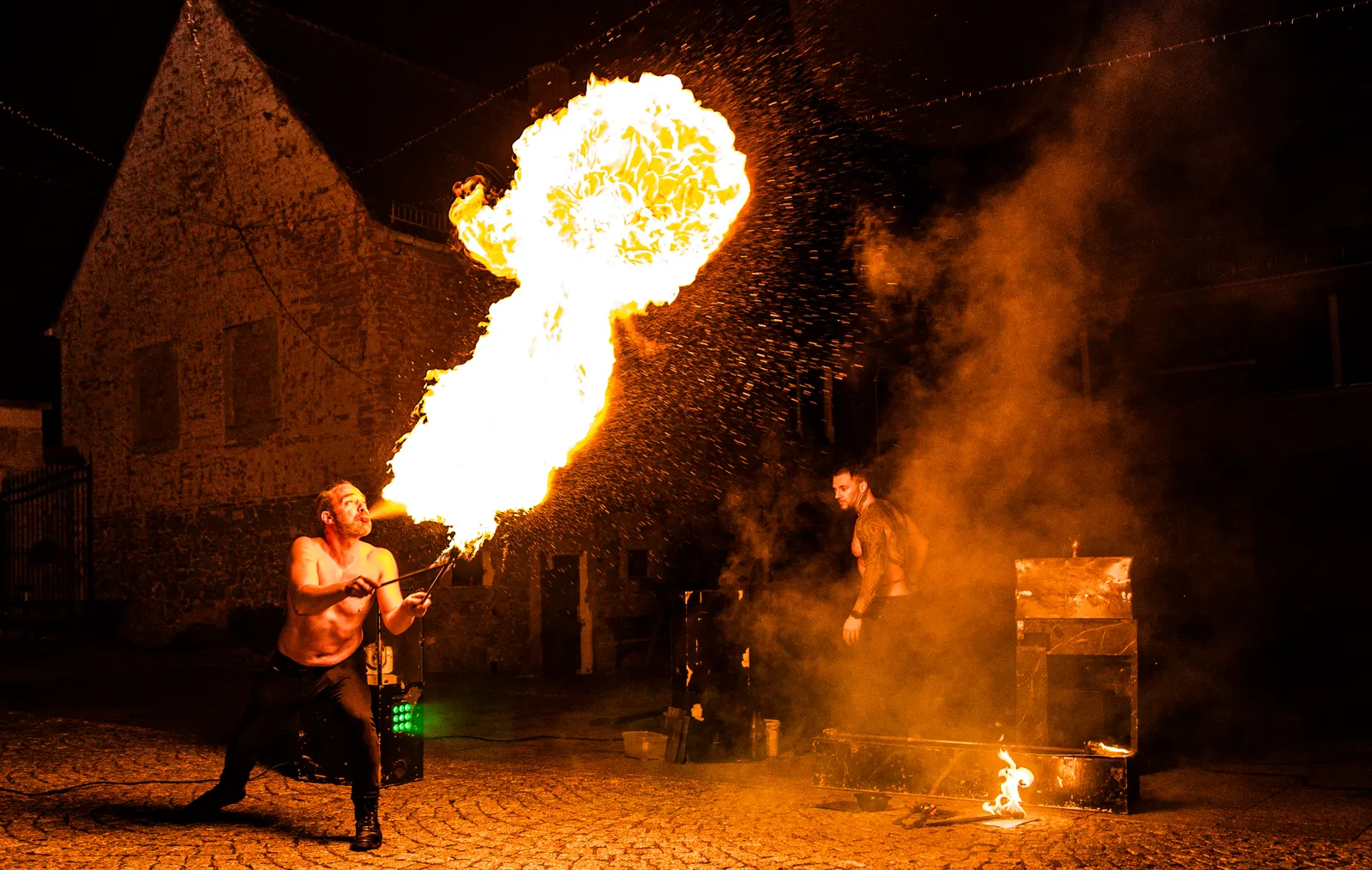 Feuerkünstler spuckt eine große Flammenwolke